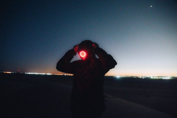 Silhouette with glowing mask in the Algerian desert under a starry night sky. Futuristic and mysterious vibe. Geek 4K