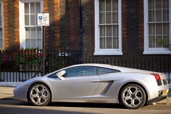 Silver Lamborghini parked in a charming city street captures luxury lifestyle. Voitures 4K