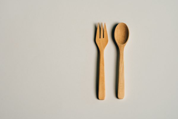 Simple and elegant wooden fork and spoon set on a soft gray background, perfect for culinary and lifestyle themes. Minimaliste 4K