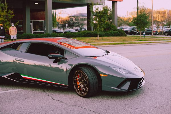 Sleek luxury sports car parked on a city street, showcasing modern design. Voitures 4K