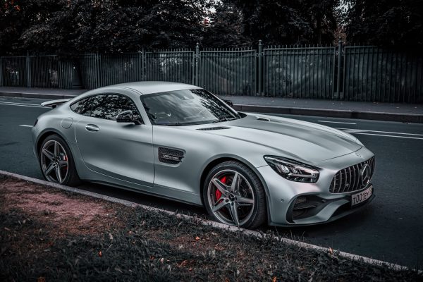 Sleek silver coupe parked on an urban street, showcasing modern design and elegance. Voitures 4K