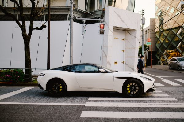 Sleek white sports car stopped at a Tokyo city intersection near designer buildings. Voitures 4K