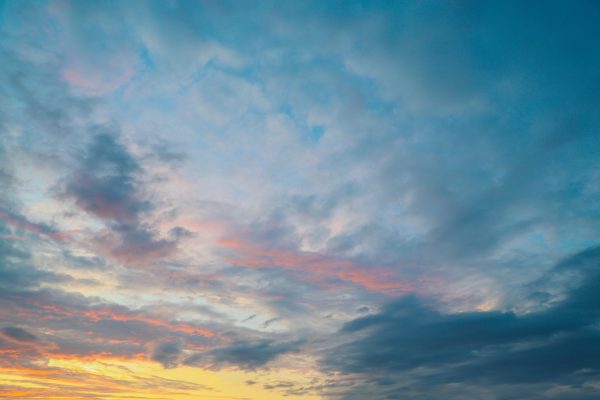 Soft textured clouds during a vibrant sunset with pastel hues of orange, pink, and blue. Nature 4K