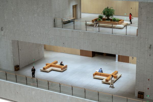 Spacious modern atrium in a Shanghai building featuring minimalistic design with people sitting and walking. Minimaliste 4K