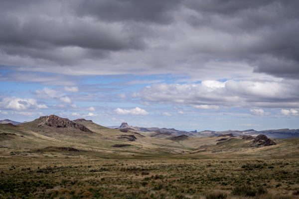 Spectacular landscape of field with dry grass and rocky hills in countryside under cloudy sky in daytime Nature 4K