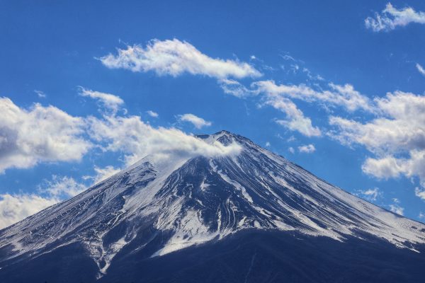 Striking photo of Mount Fuji with snow and clouds against a blue sky, showcasing natural beauty. Anime 4K