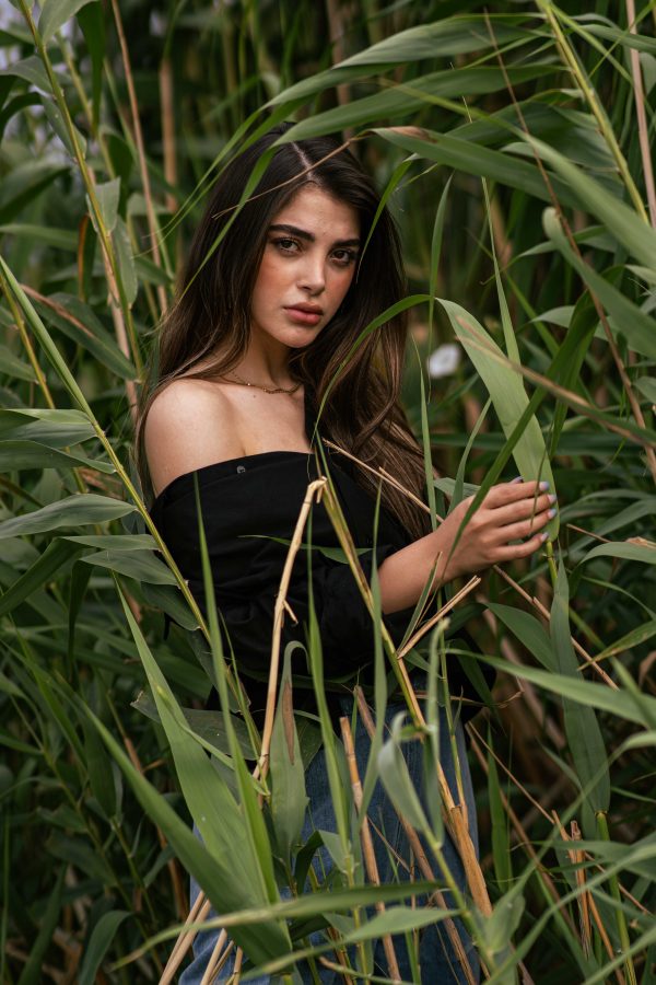 Striking portrait of a woman surrounded by verdant reeds, capturing a natural and serene setting. Mobile 4K