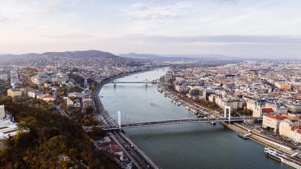 Stunning aerial view of Budapest featuring the Danube River and iconic city bridges during the day. Architecture 4K