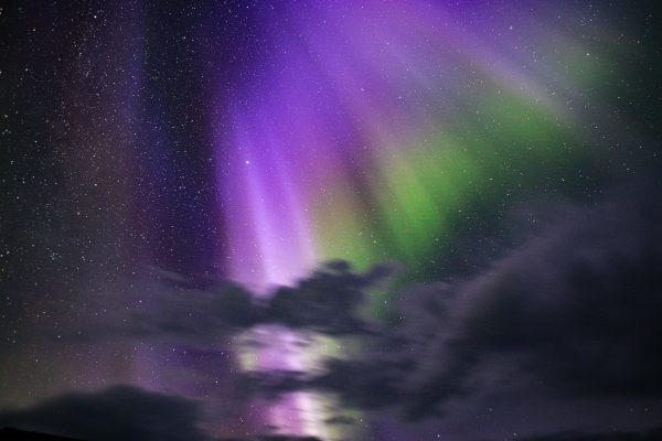 Stunning aurora borealis in vibrant greens and purples against a starry night sky. Espace 4K