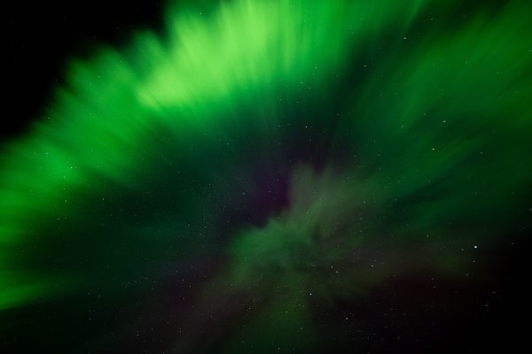 Stunning green aurora borealis illuminating the starry night sky over Iceland. Espace 4K