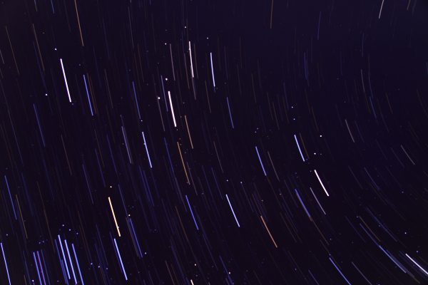 Stunning long exposure image capturing vivid star trails against a deep night sky, showcasing celestial movement.
