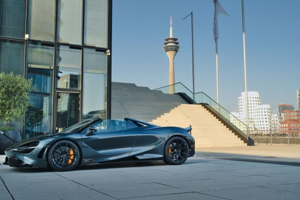 Stunning luxury sports car parked outdoors with the iconic Rhine Tower in Düsseldorf, Germany. Voitures 4K