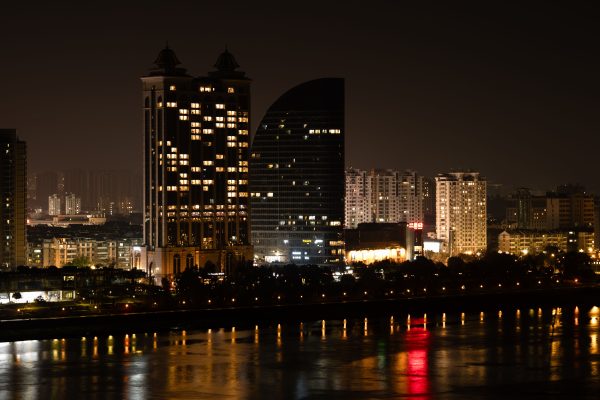 Stunning nighttime view of Hangzhou's illuminated skyline reflecting on the river. Architecture 4K