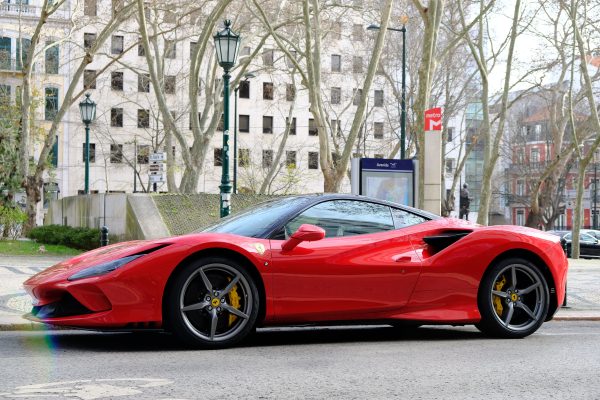 Stunning red Ferrari sports car elegantly parked in a picturesque Lisbon street. Voitures 4K