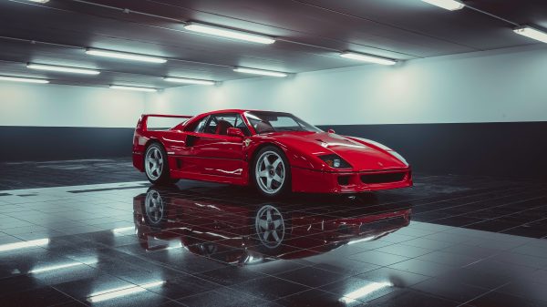 Stunning red Ferrari sports car showcased in a sleek indoor parking area. Voitures 4K