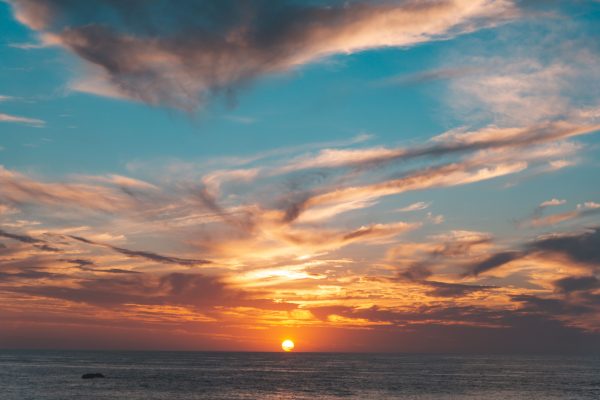 Stunning sunset over the ocean with vivid colors and dramatic clouds creating a mesmerizing scene. Nature 4K