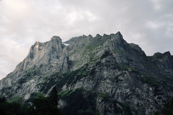 Stunning view of a rugged mountain under an overcast sky, showcasing natural beauty and dramatic terrain. Nature 4K