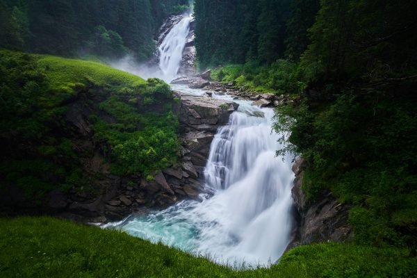 Stunning view of Krimml Waterfalls cascading through lush greenery in summer. Nature 4K