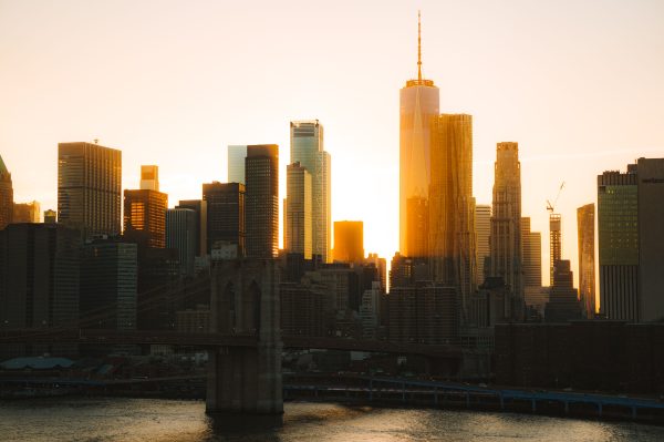 Stunning view of NYC skyline with skyscrapers and Brooklyn Bridge at sunset. Architecture 4K