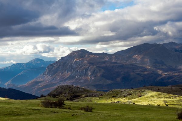 Stunning view of the mountains and green fields under a cloudy sky in Žabljak, Montenegro. Nature 4K