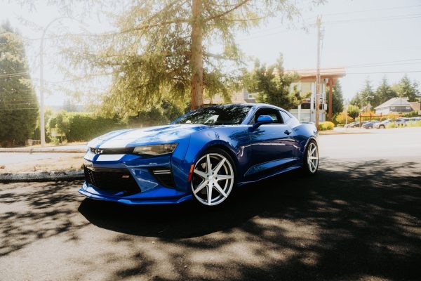 Stylish blue sports car parked on a sunny day in a suburban neighborhood street. Voitures 4K