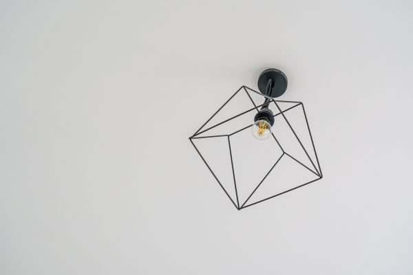Stylish modern ceiling light fixture with a geometric design on a white background. Minimaliste 4K