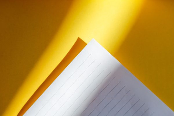 Stylish photo of lined paper on bright yellow background. Minimaliste 4K
