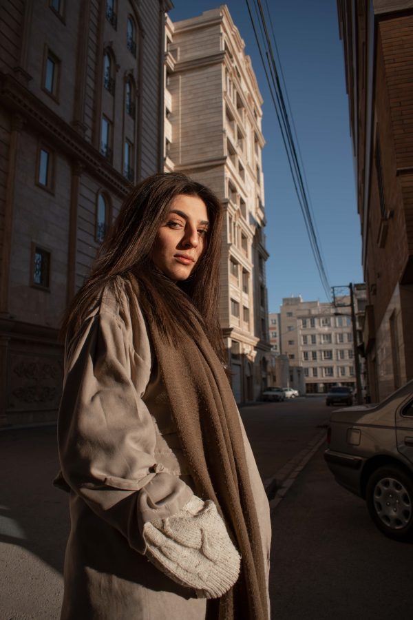 Stylish woman in urban street setting with architectural background captured in warm afternoon light. Mobile 4K