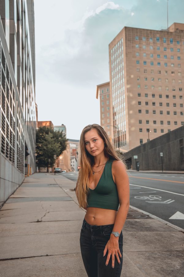 Stylish woman stands confidently on a city street, embodying urban lifestyle. Mobile 4K