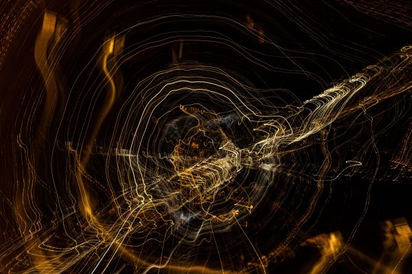 Swirling light trails create an abstract pattern against a dark background, evoking motion and energy. Abstrait 4K