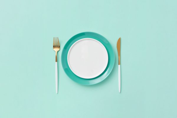 Teal plate set with fork and knife on a matching background. Minimalist and modern design. Minimaliste 4K