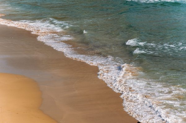 Tranquil scene of ocean waves gently washing ashore on a sandy beach in Ireland. Nature 4K