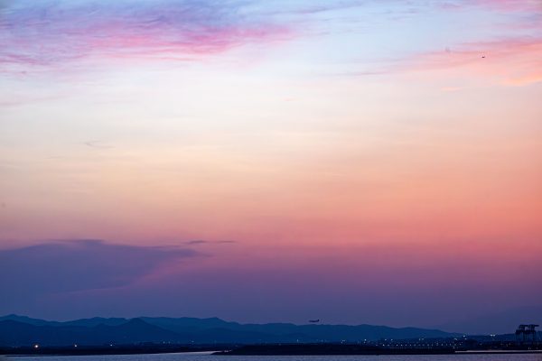 Tranquil twilight sky over a serene landscape with distant mountains, captured in vivid colors. Nature 4K