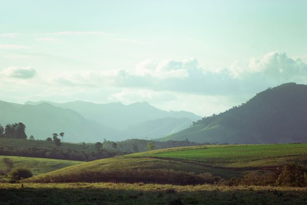 Tranquil view of lush green hills and distant mountains under a cloudy sky in Brazil. Nature 4K