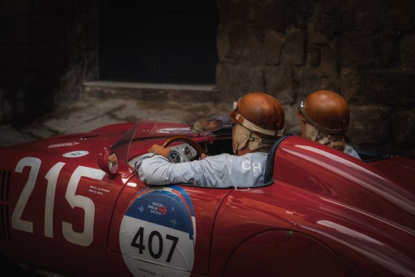 Two drivers in vintage helmets inside a classic red race car. Voitures 4K