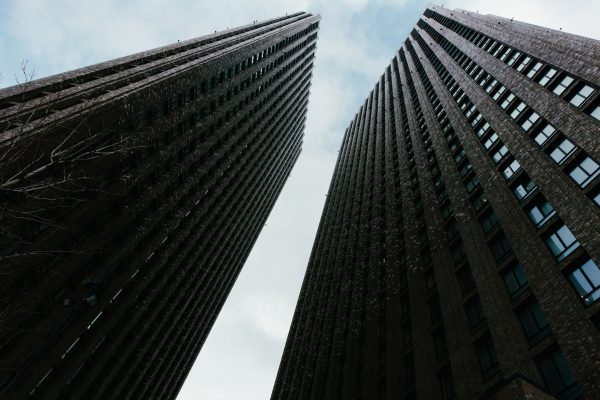 Two tall skyscrapers stretch upwards against a cloudy sky, showcasing modern urban architecture. Architecture 4K