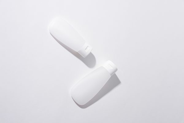 Two white cosmetic containers in a minimalist flat lay composition on a neutral background. Minimaliste 4K
