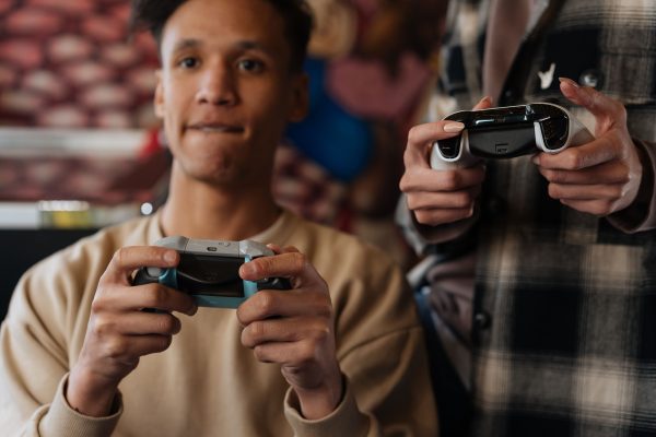 Two young adults intensely focused on playing video games with controllers indoors. Gaming 4K