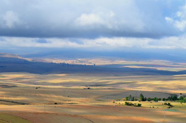 Vast South African landscape with fields under a cloudy sky, showcasing nature's beauty. Nature 4K