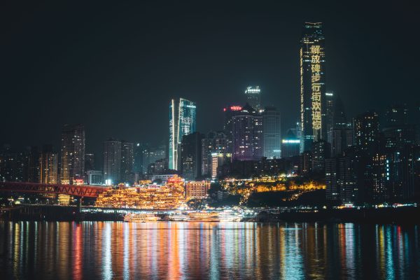 Vibrant Chongqing skyline at night with city lights reflecting in Yangtze River. Architecture 4K