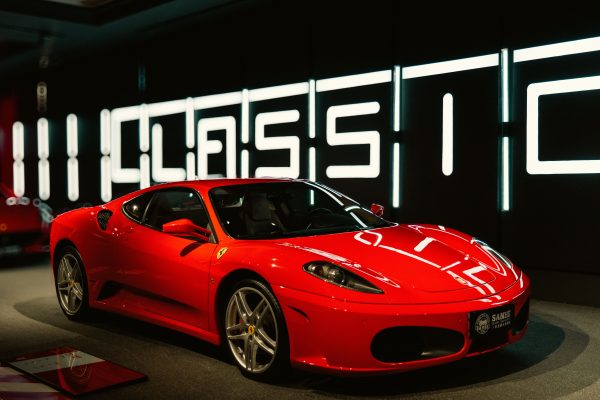 Vibrant red sports car displayed in a modern and stylish showroom with classic design. Voitures 4K