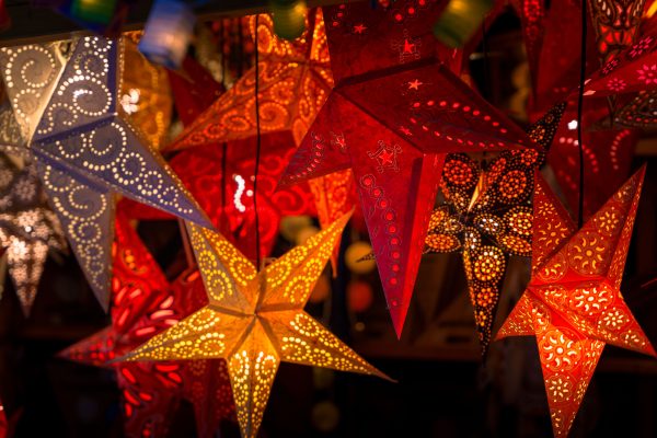Vibrant star-shaped paper lanterns beautifully lit up, typical of German Christmas markets. Espace 4K