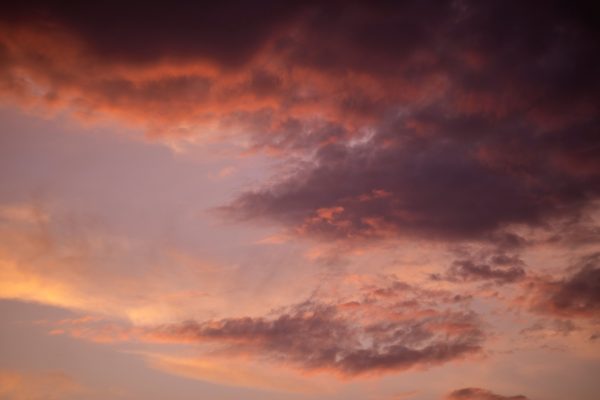 Vibrant sunset sky with dramatic purple and orange cloud formations. Dark 4K