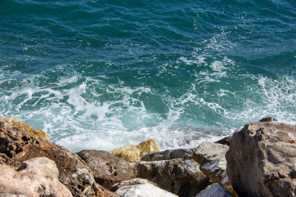 Vivid blue waves crashing against rocky shore in Marbella, Spain, showcasing Mediterranean beauty. Nature 4K