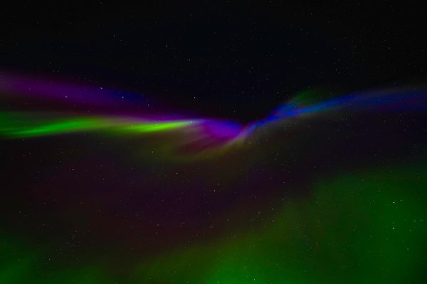 Vivid Northern Lights display in Norway's night sky, showcasing green, purple, and blue hues against starry backdrop. Espace 4K