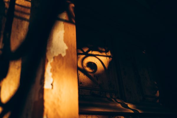 Warm, artistic shadow play on an aged wooden surface in low light, creating a mysterious ambiance. Dark 4K