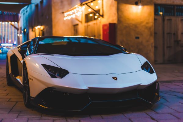 White sports car with sleek design parked in an urban night setting with ambient lighting. Voitures 4K