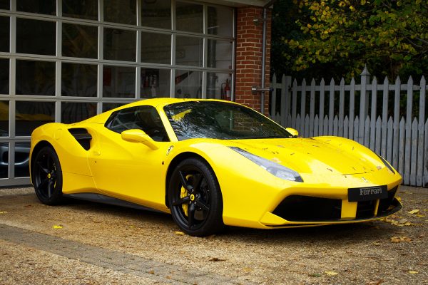 Yellow Ferrari sports car parked outside a garage in the UK. Voitures 4K