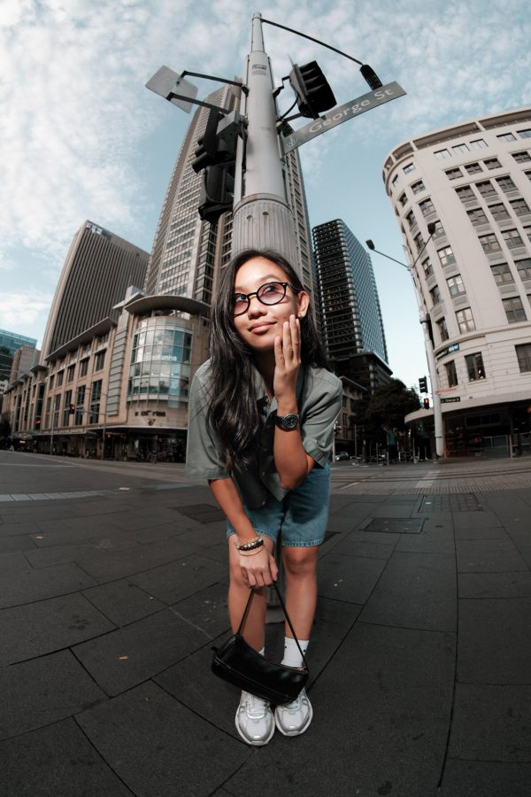 Young woman posing confidently in downtown Sydney with skyscrapers in the background. Mobile 4K